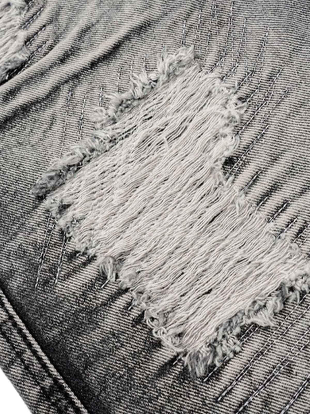 Intricate look at distressed fabric on TALISHKO denim shorts, emphasizing rugged texture.