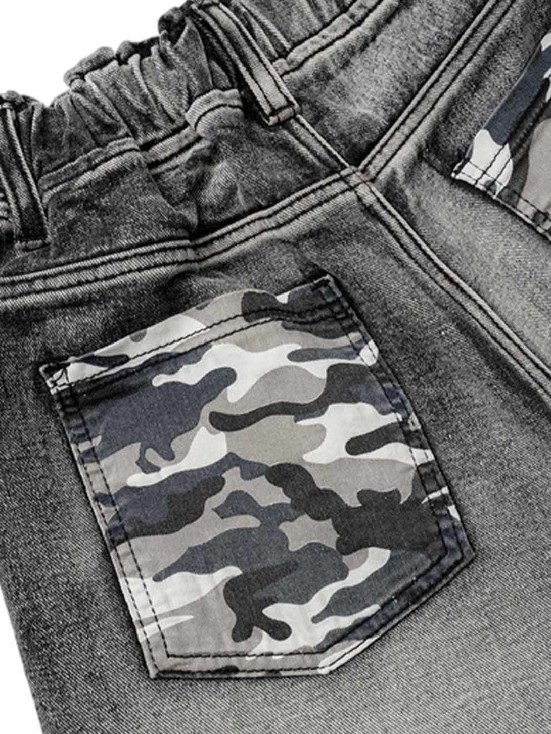 Detailed view of TALISHKO denim shorts, highlighting camouflage pocket and elastic waistband.