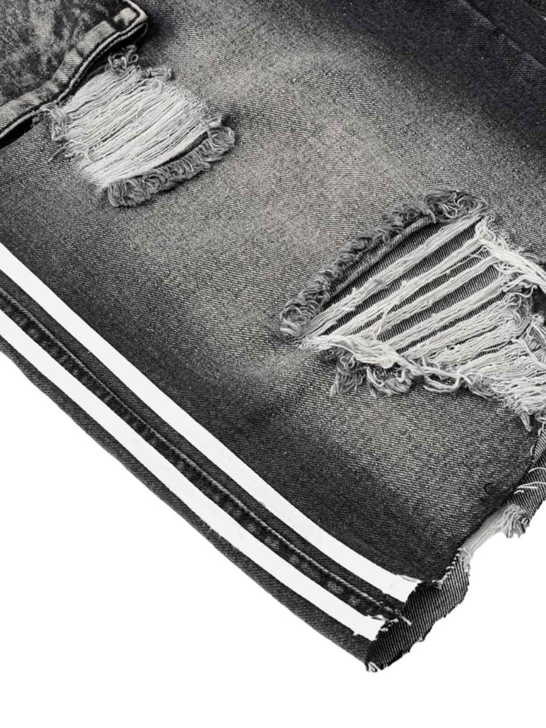 Zoomed-in detail of distressed denim shorts by TALISHKO, showcasing rugged texture and design.