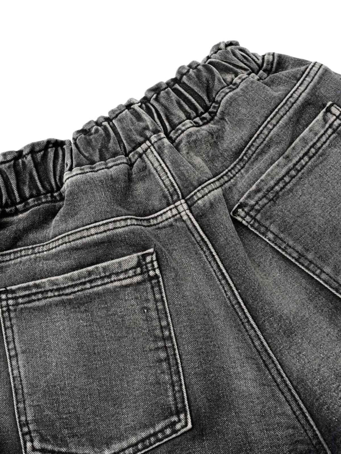Intricate look at the back of distressed cargo denim shorts by TALISHKO, highlighting elastic detail.