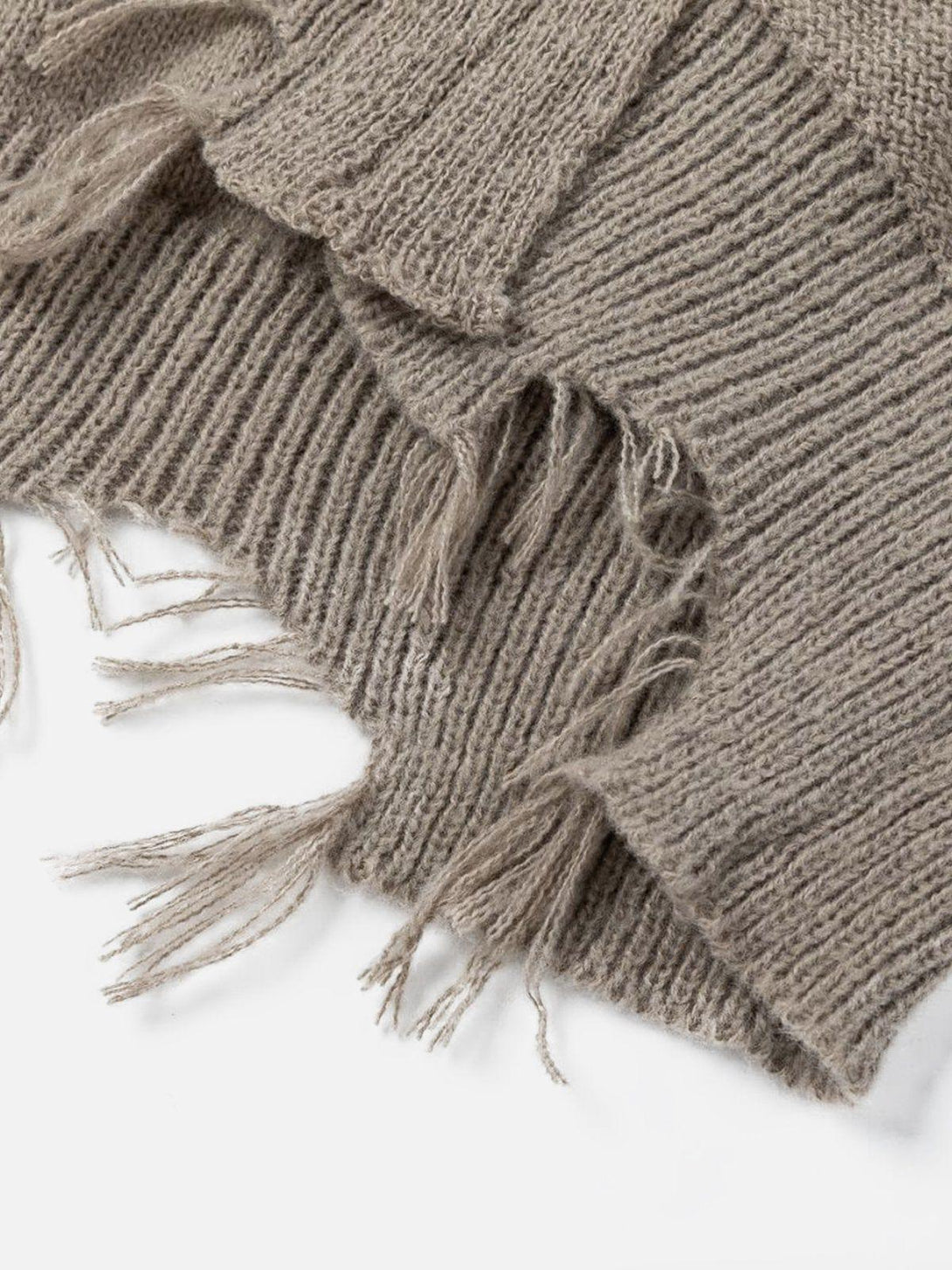 Intricate look at the taupe distressed patchwork sweater texture by TALISHKO, featuring frayed edges.