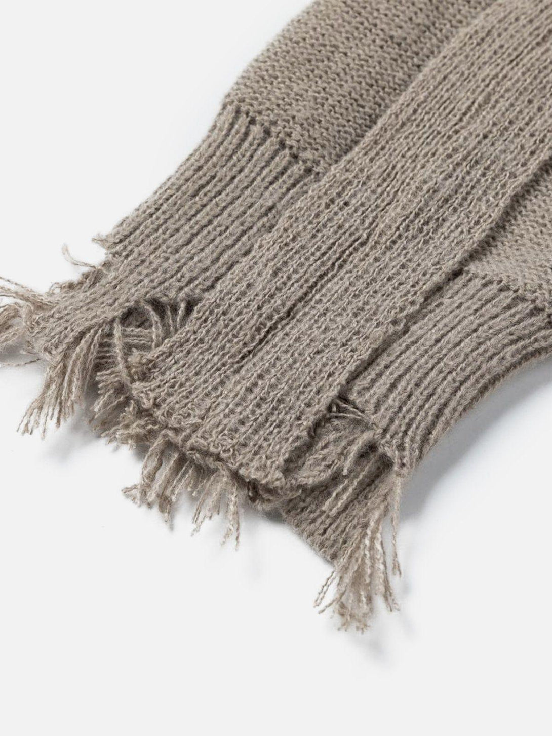 Frayed texture detail of a taupe patchwork sweater by TALISHKO, highlighting deconstructive design.