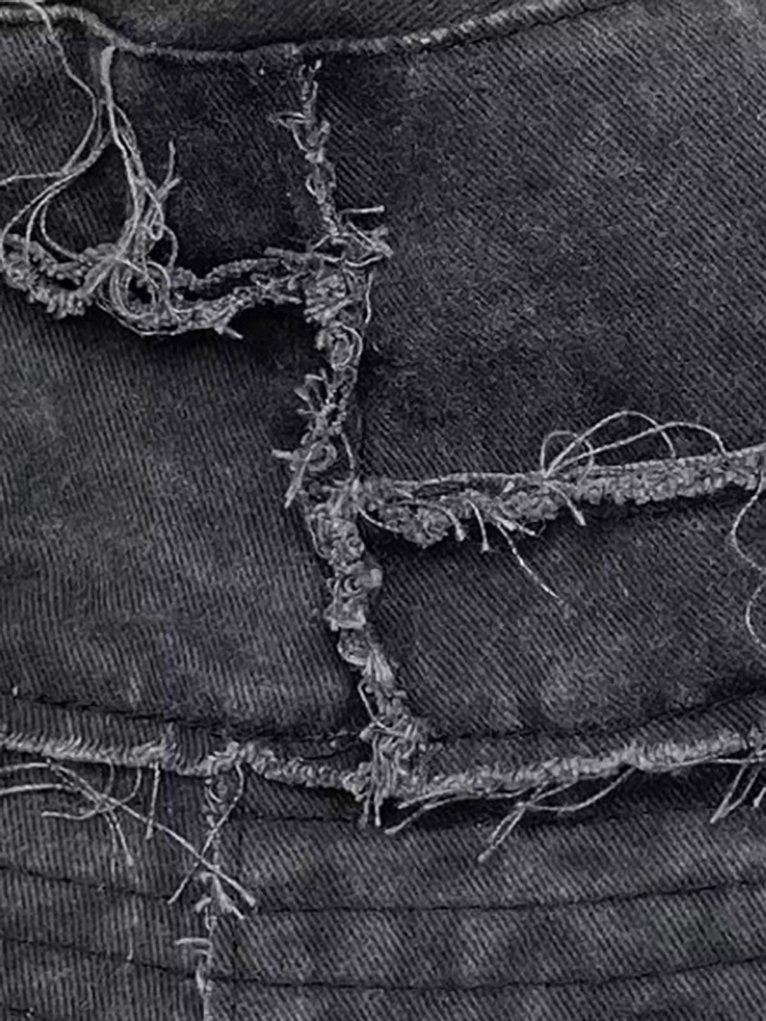 A detailed view of TALISHKO's distressed denim bucket hat with raw edges and frayed texture.