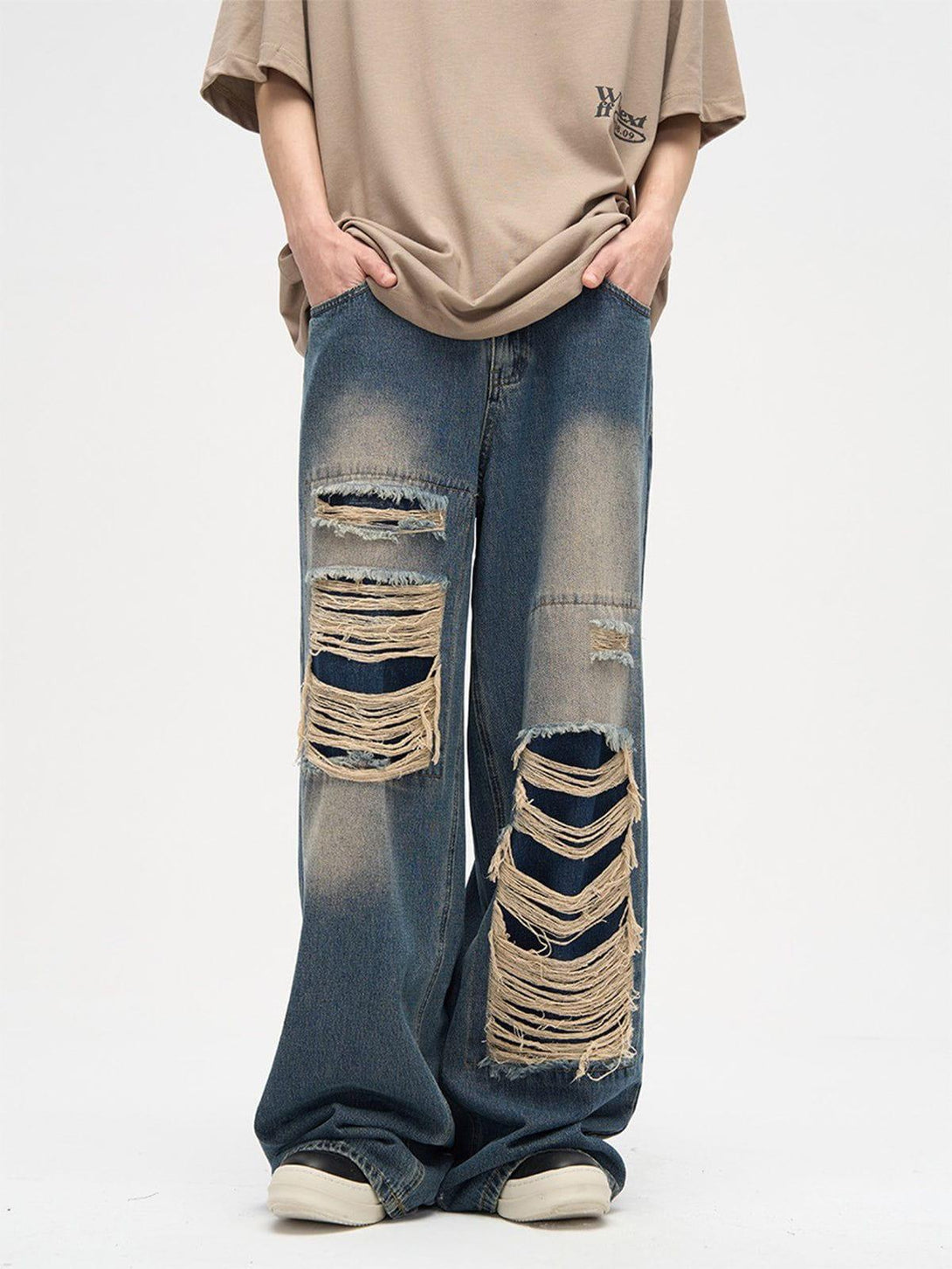 Model wearing TALISHKO distressed loose jeans with bold rips, perfect for casual street style.