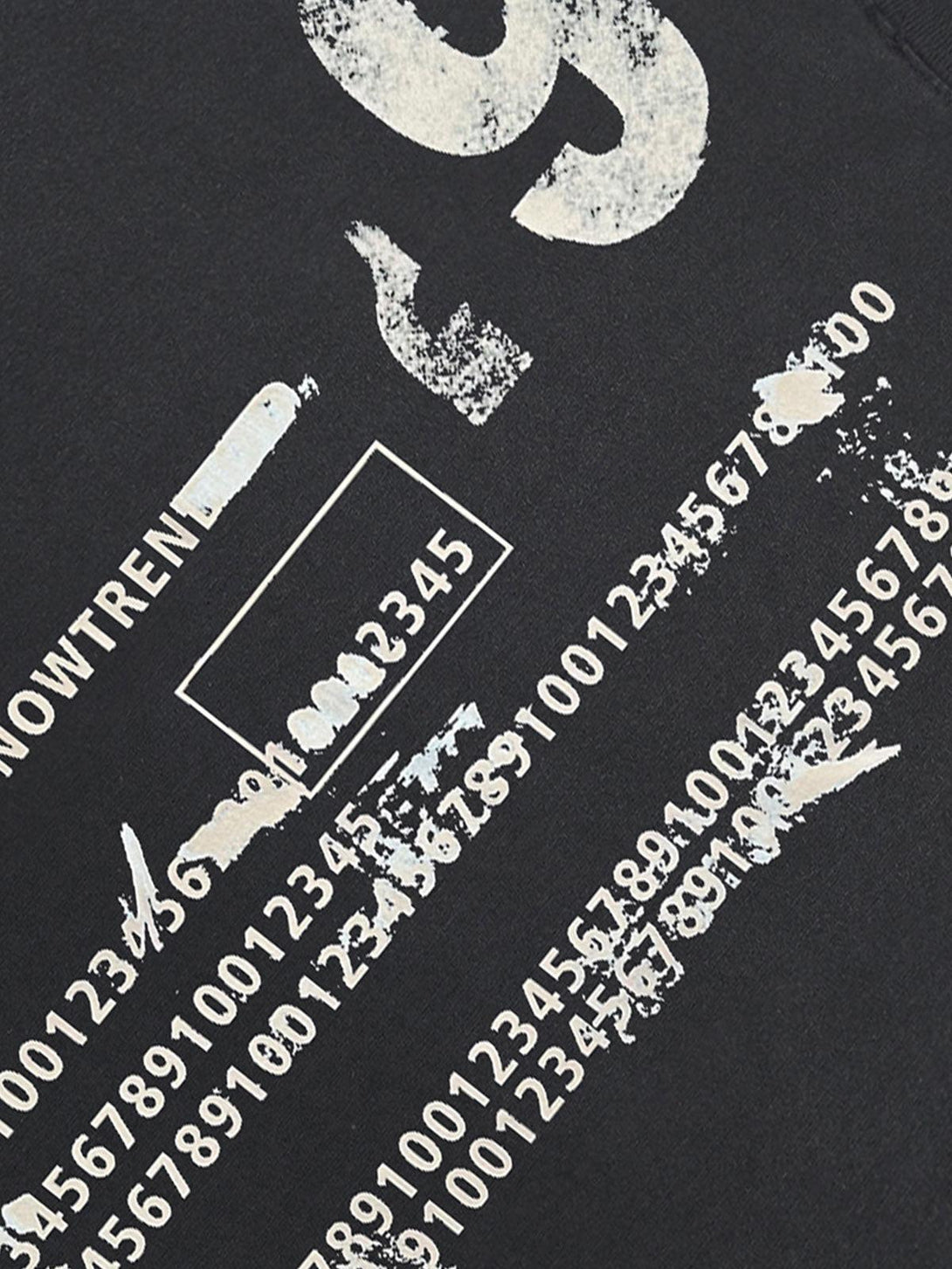 A detailed view of the distressed print on a black T-shirt by TALISHKO, featuring numeric graphics.