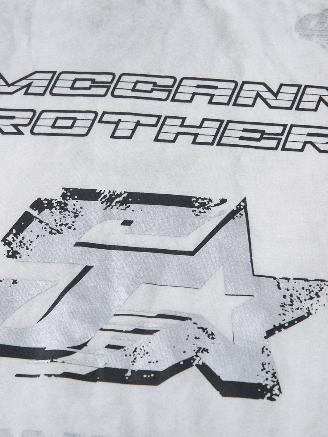 A close-up of a distressed design on a TALISHKO T-shirt, highlighting unique print details.