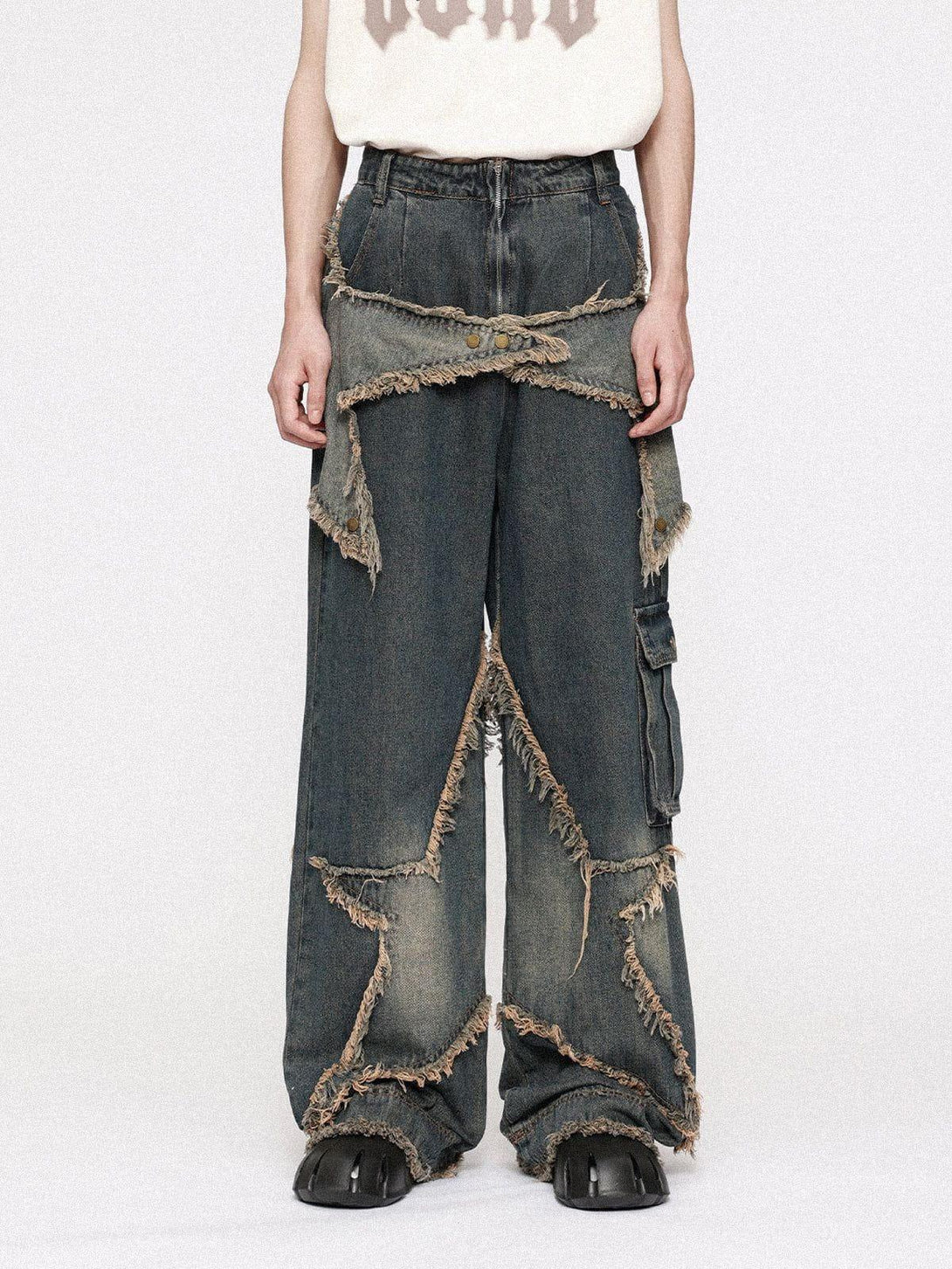 Wearing TALISHKO star patchwork denim jeans with frayed edges and a bold distressed look.
