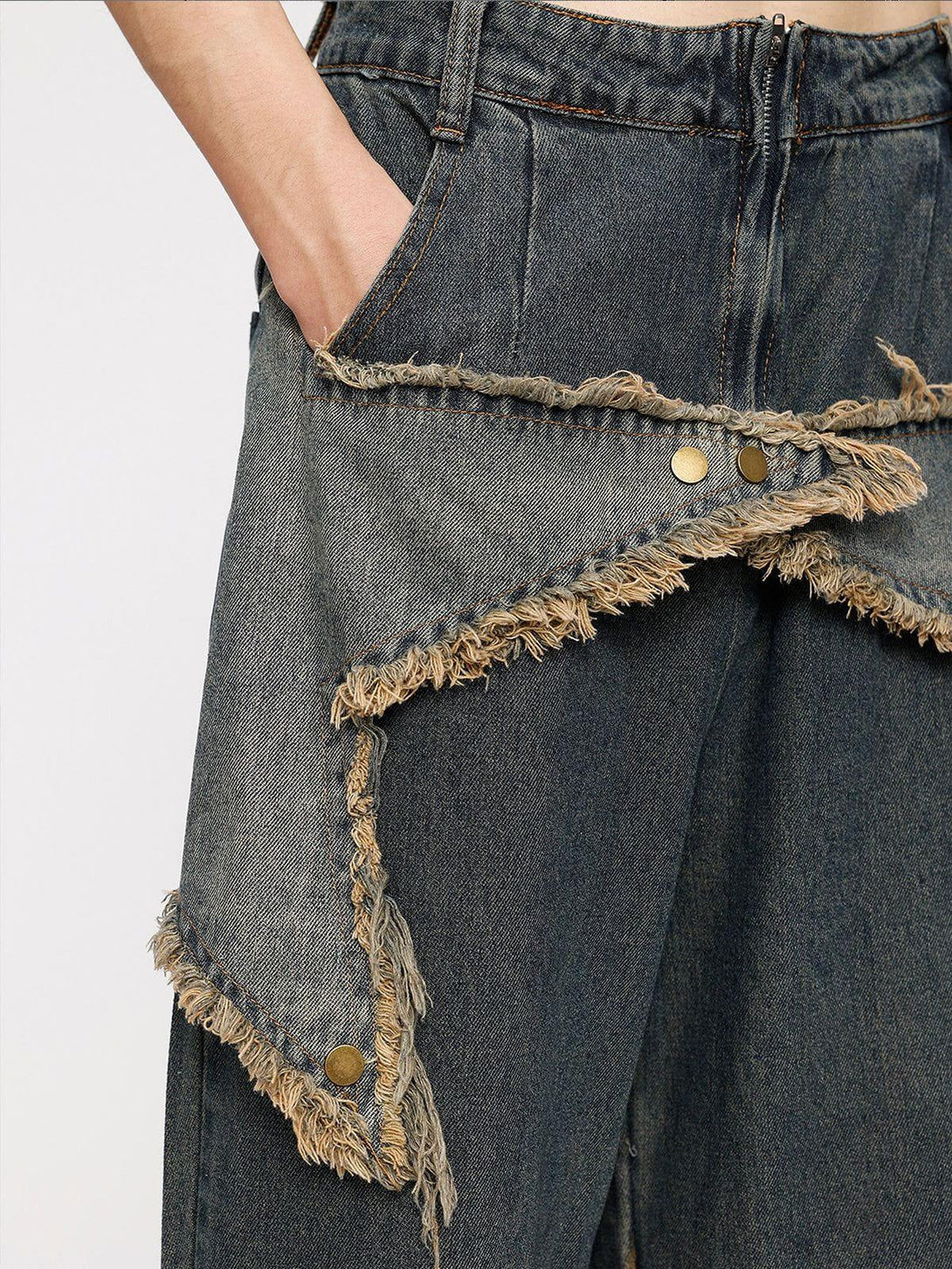 Frayed star patchwork detail on TALISHKO denim jeans, highlighting unique distressed design.
