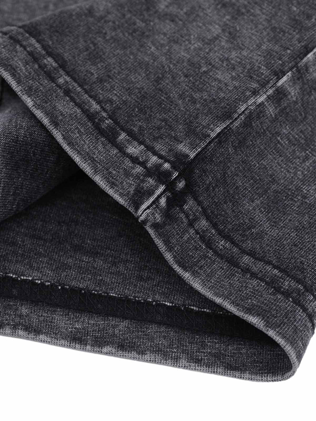 Embroidery and denim collar detail on TALISHKO's distressed polo shirt, showcasing craftsmanship.