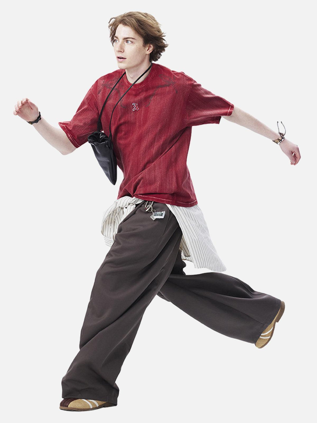 Model in a red distressed T-shirt by TALISHKO, paired with wide pants for a casual summer look.
