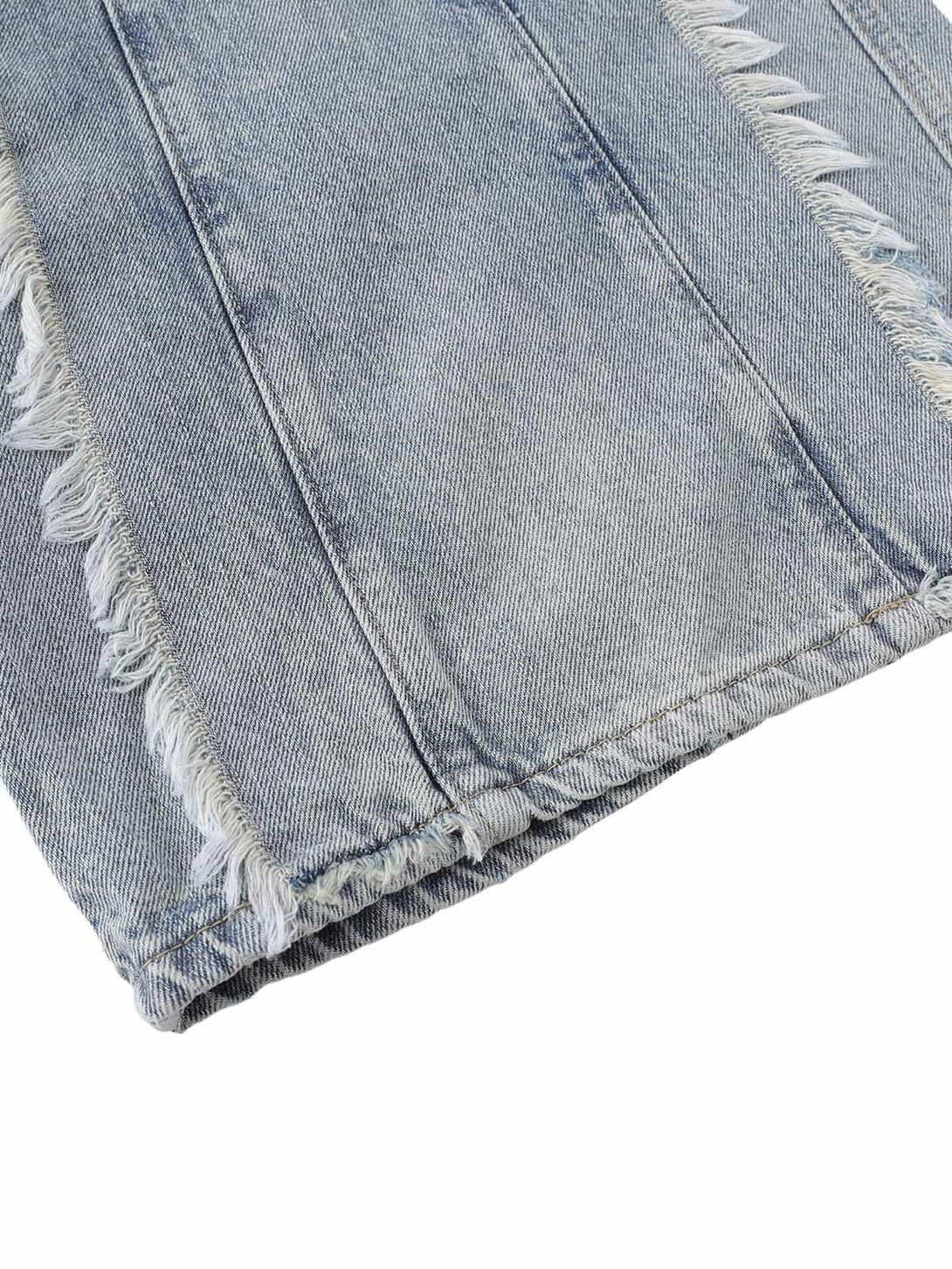 Zoomed-in texture of TALISHKO's distressed baggy jeans, highlighting frayed edge details.