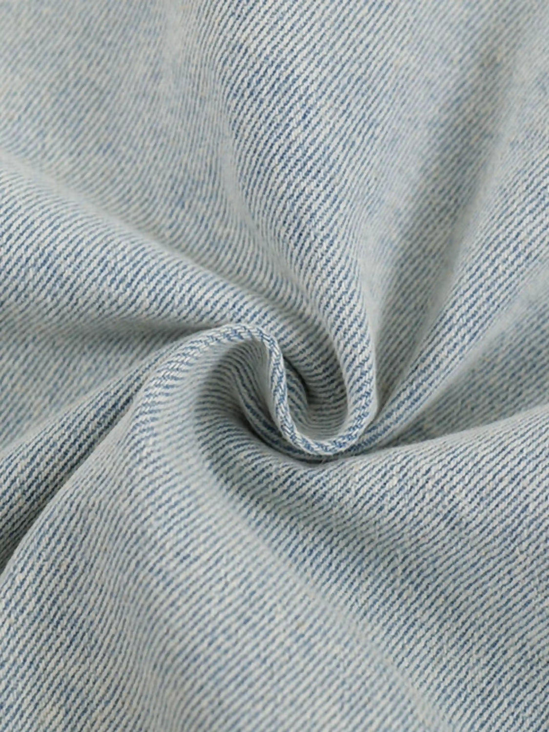 Intricate look at the blue denim fabric by TALISHKO, highlighting its unique texture and weave.