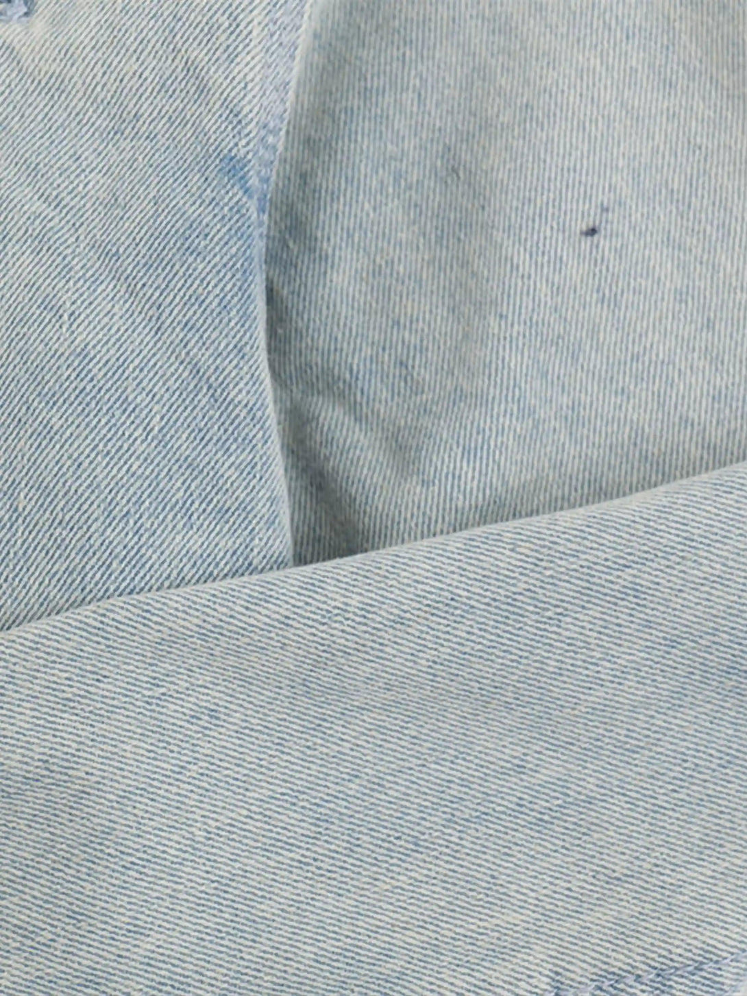 Zoomed-in texture of TALISHKO denim jacket fabric, highlighting its soft weave and blue hue.