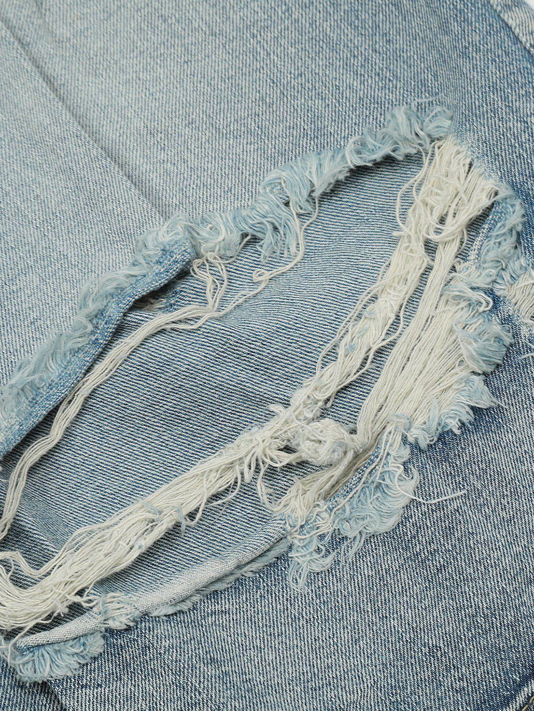 A close-up of TALISHKO distressed fringe jorts, highlighting the intricate frayed detailing.