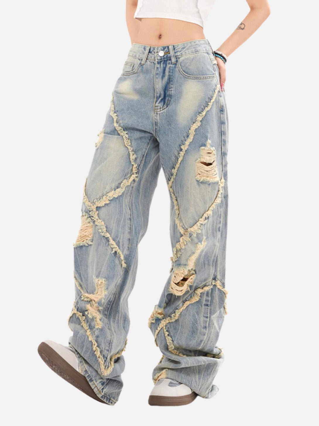 Model in loose distressed jeans with fringe details by TALISHKO, highlighting casual streetwear.