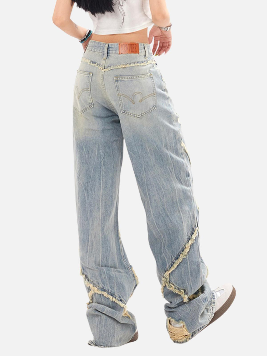 Model in TALISHKO loose jeans with fringe and distressed details, embodying relaxed urban style.