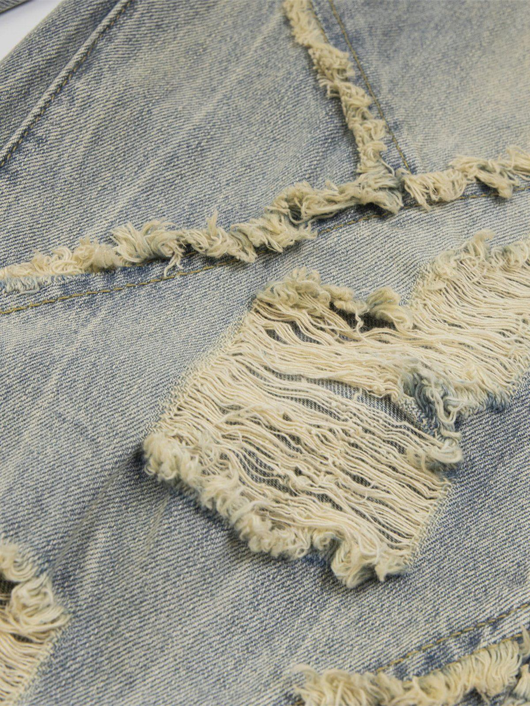 Intricate look at TALISHKO distressed jeans, showcasing fringe details and unique texture.