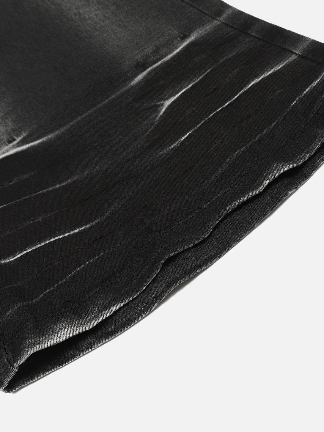 Zoomed-in texture of washed jeans by TALISHKO, focusing on the unique distressed finish.