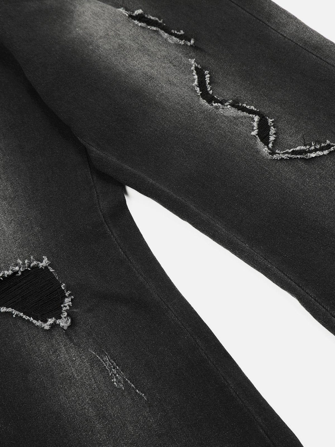 A close-up look at distressed fringe details on washed jeans by TALISHKO, showcasing edgy style.