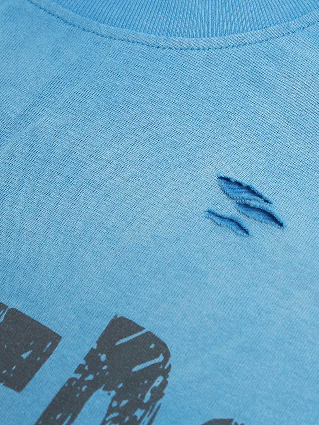 A detailed view of TALISHKO's blue crew neck T-shirt, highlighting distressed fabric details.