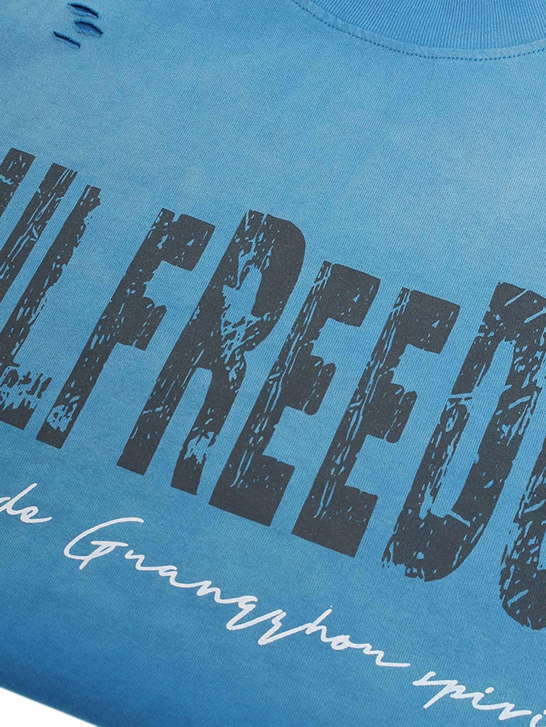 Zoomed-in view of TALISHKO's blue distressed T-shirt, highlighting bold letter print detail.