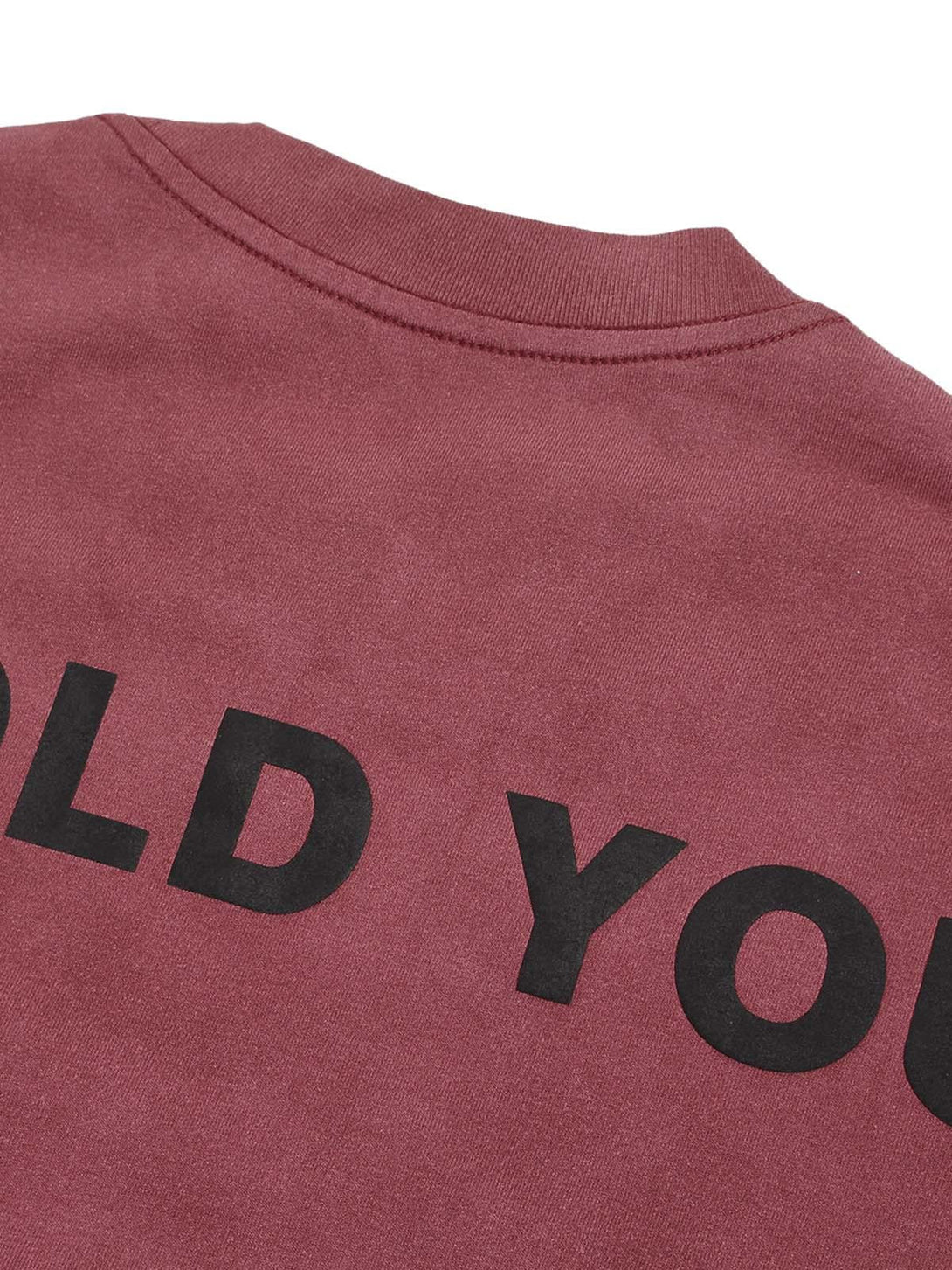 Detailed look at the back of a TALISHKO T-shirt, highlighting bold black lettering on red fabric.