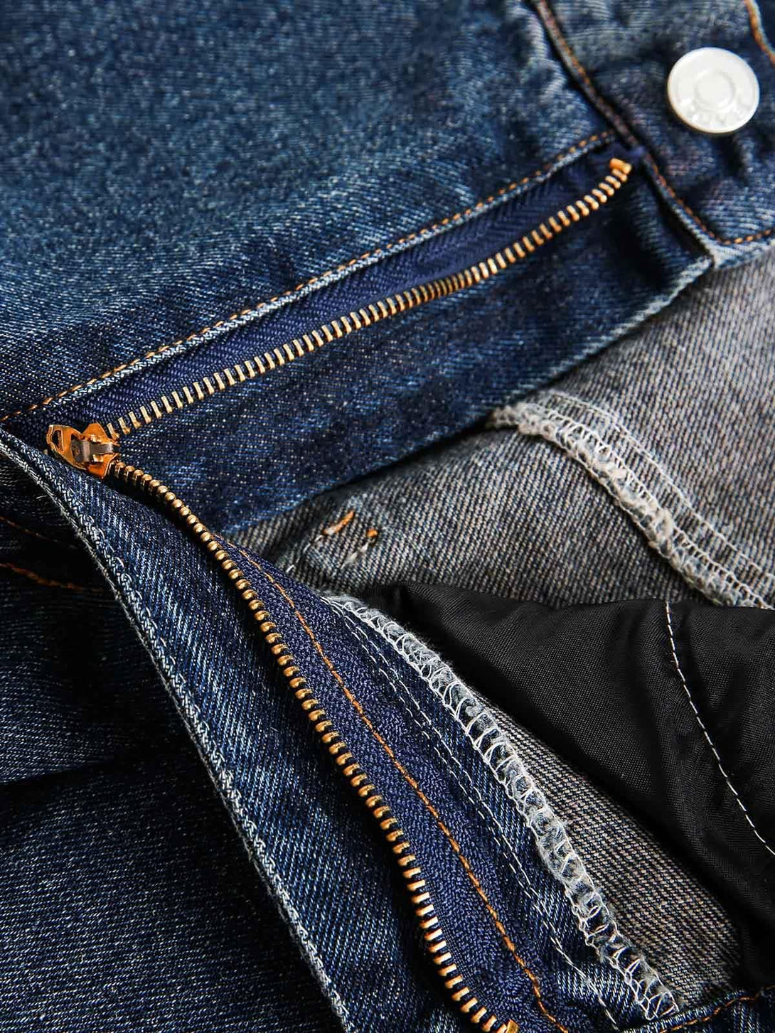 Intricate look at TALISHKO jeans' zipper, showcasing detailed stitching and denim texture.