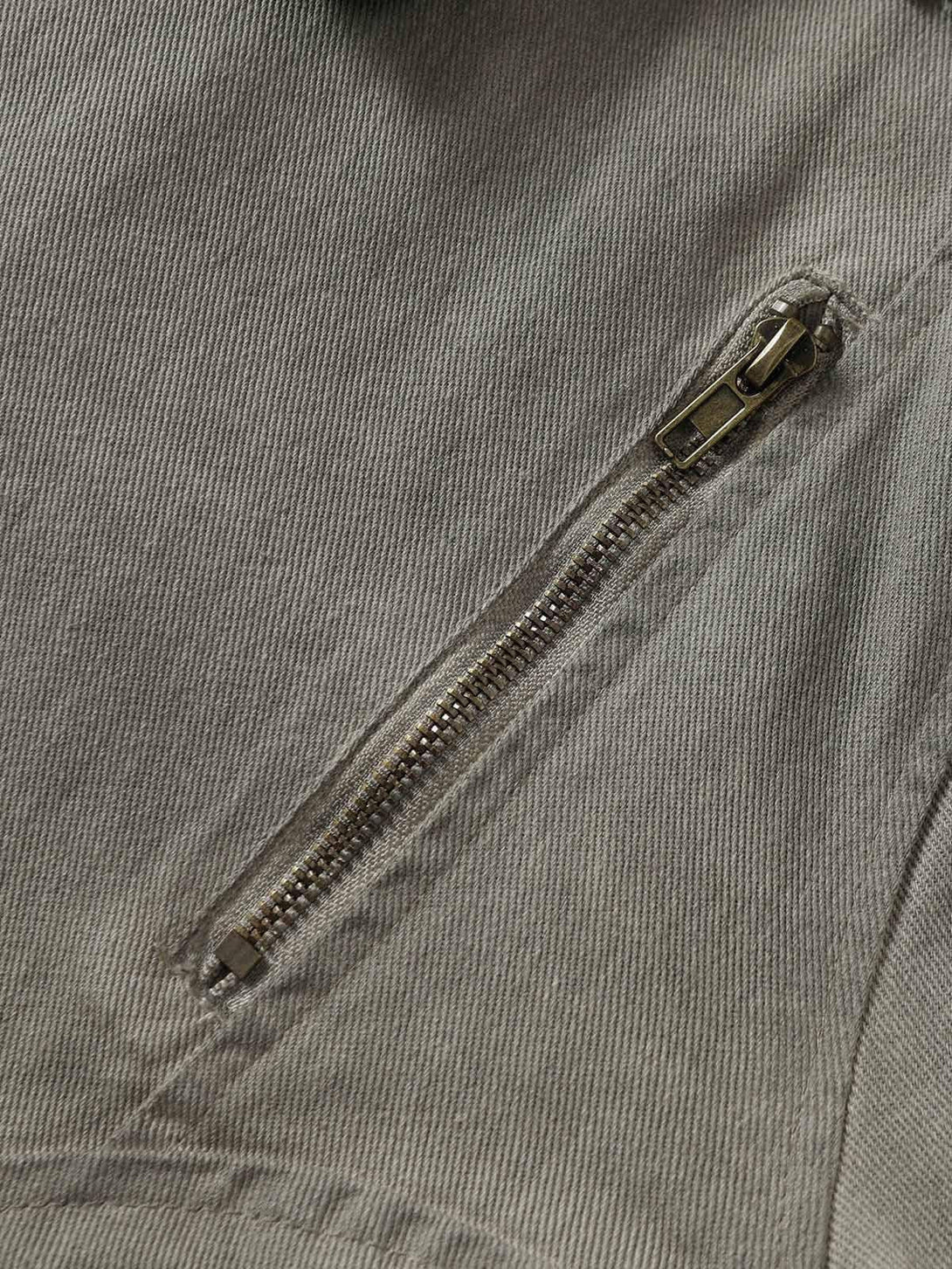 A detailed view of the TALISHKO denim jacket's zipper and stitching, highlighting its unique texture.