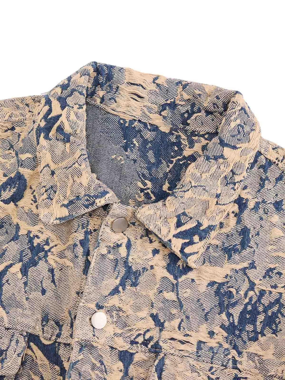 A detailed view of the distressed jacquard fabric on a denim jacket by TALISHKO, highlighting texture.