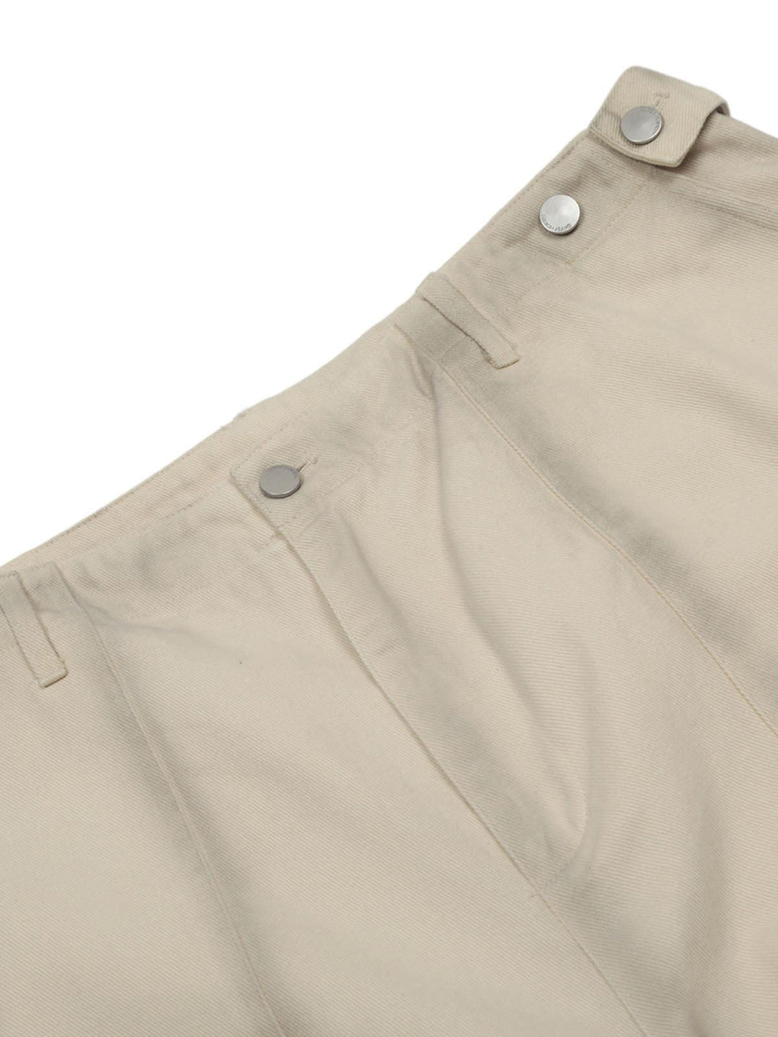 Focusing on TALISHKO cargo jorts, detailed view of beige fabric and button accents.