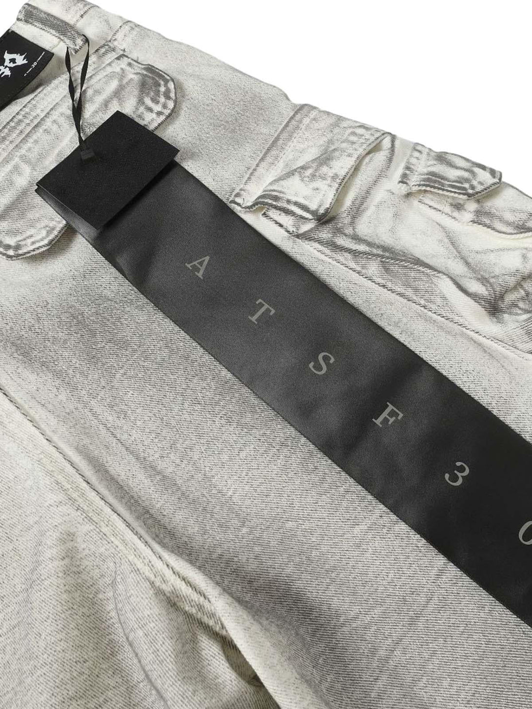Close-up of TALISHKO distressed cargo shorts, highlighting unique fabric texture and rugged style.