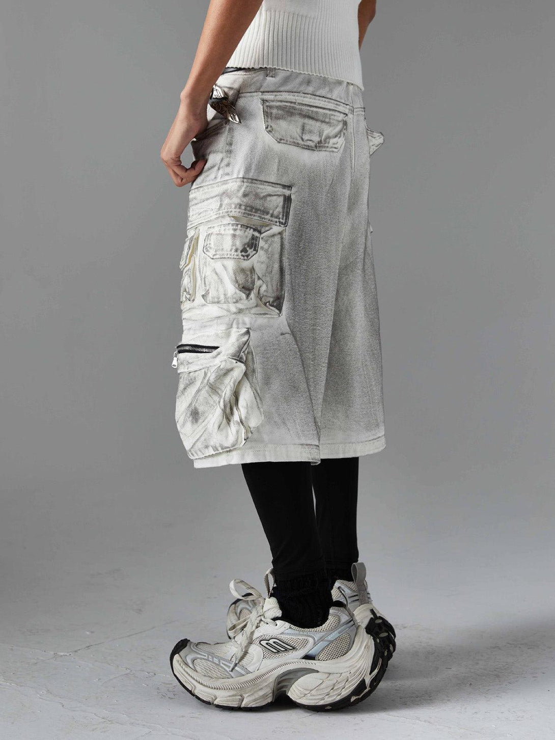 Side view of TALISHKO distressed cargo shorts with multiple pockets, paired with chunky sneakers.
