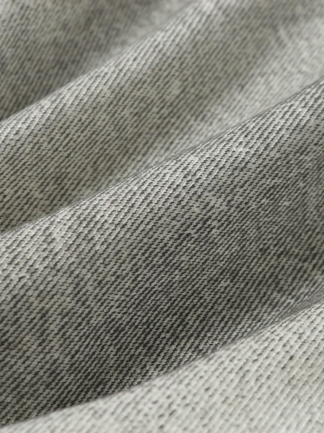Zoomed-in texture of TALISHKO distressed cargo shorts fabric, showcasing rugged pattern.