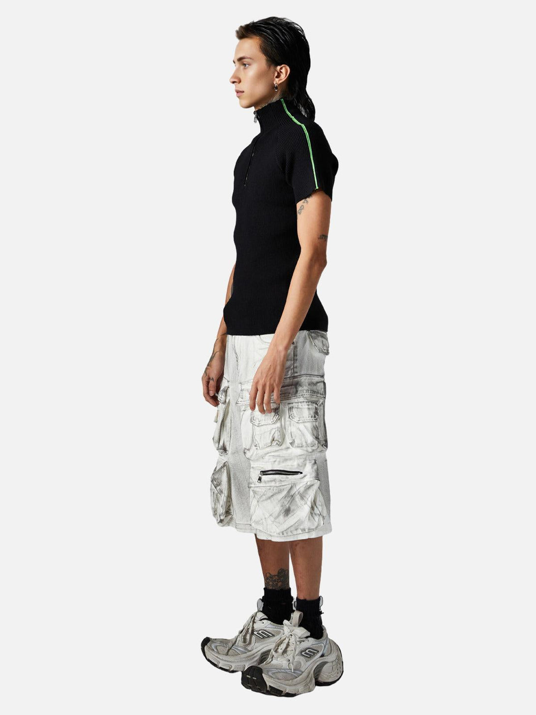 Model in TALISHKO black top and distressed cargo shorts, highlighting edgy summer style.
