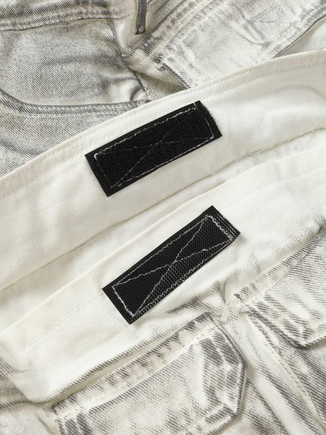 Detailed fabric and stitching of TALISHKO distressed cargo shorts, highlighting rugged style.