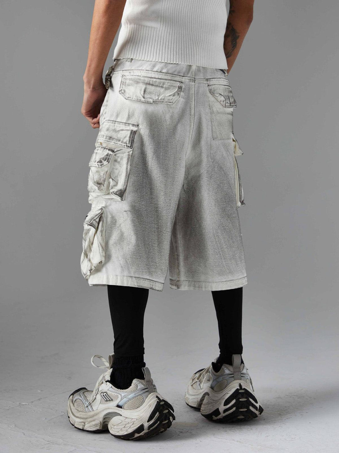 Back view of TALISHKO distressed cargo shorts with multiple pockets, paired with chunky sneakers.