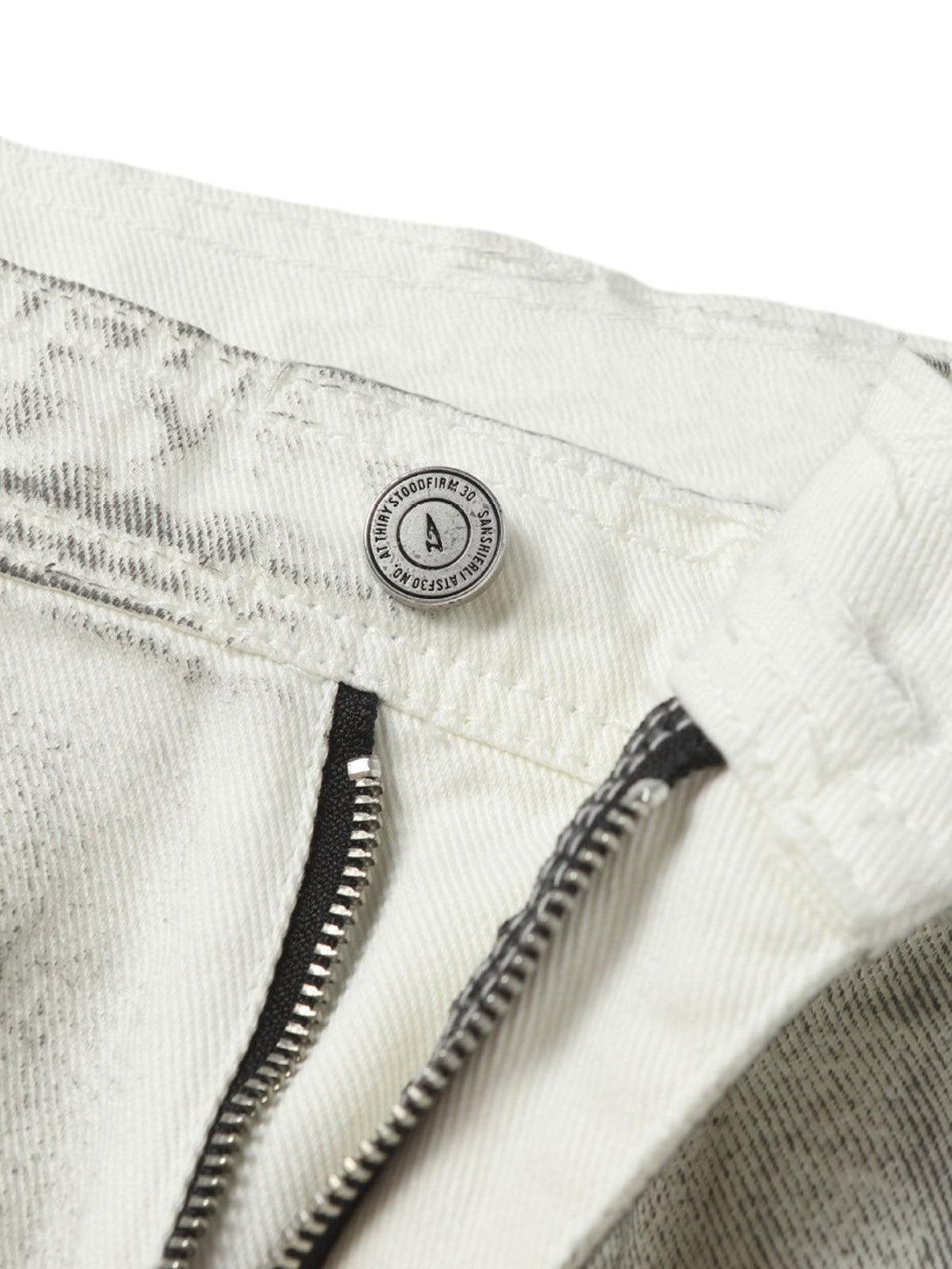 Focusing on the TALISHKO distressed shorts zipper and button detail, emphasizing rugged design.