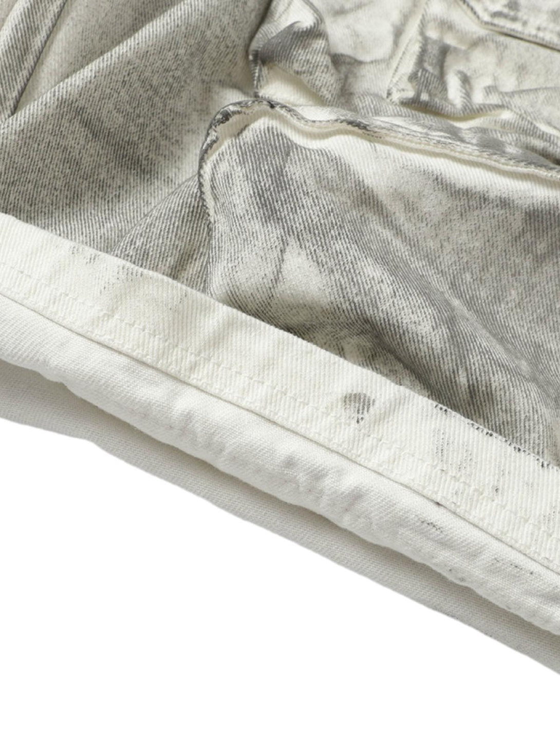 A detailed view of TALISHKO distressed cargo shorts, showcasing rugged fabric and stitching.