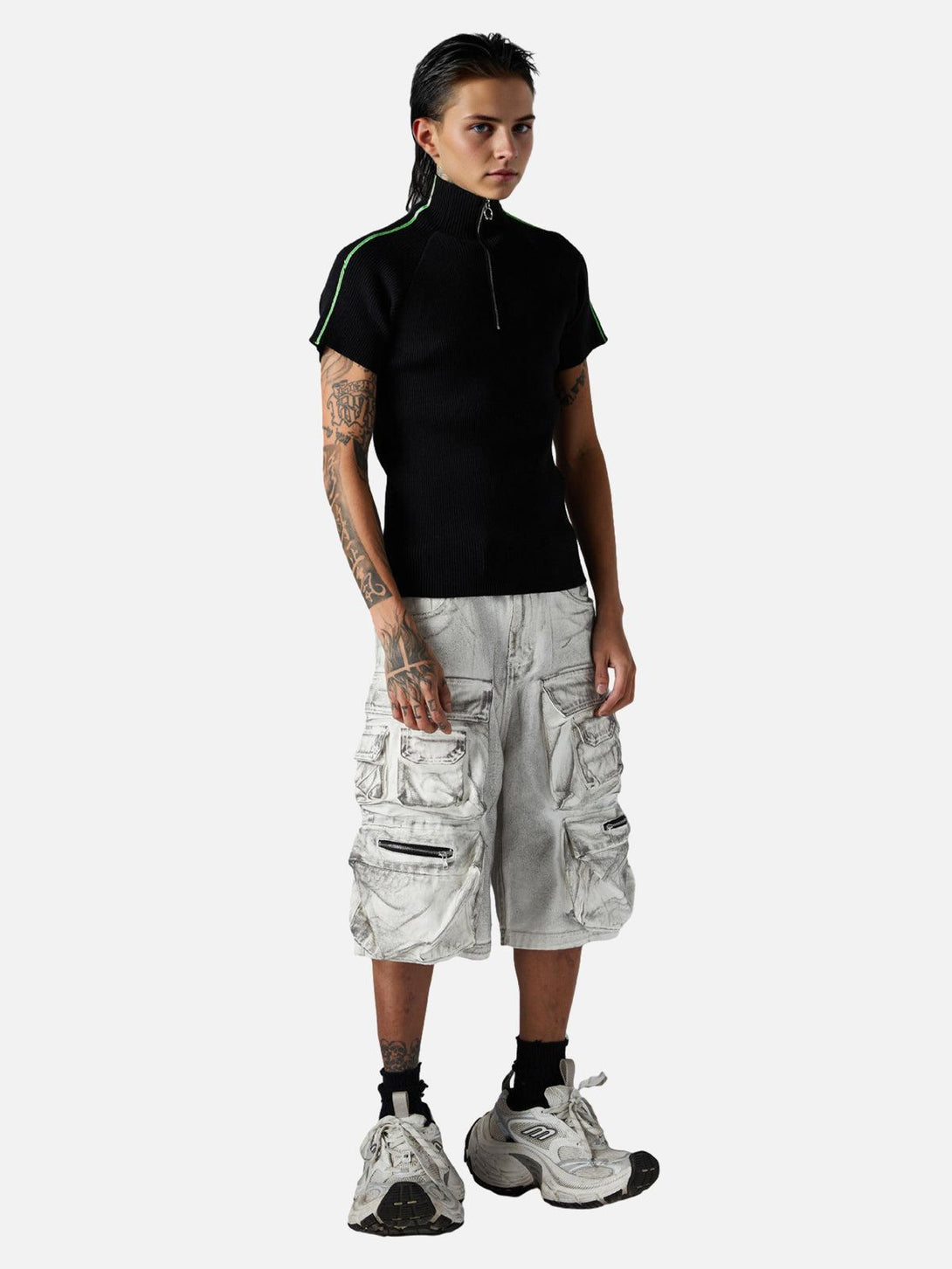 Model showcasing TALISHKO distressed cargo shorts, paired with a black top and sneakers.