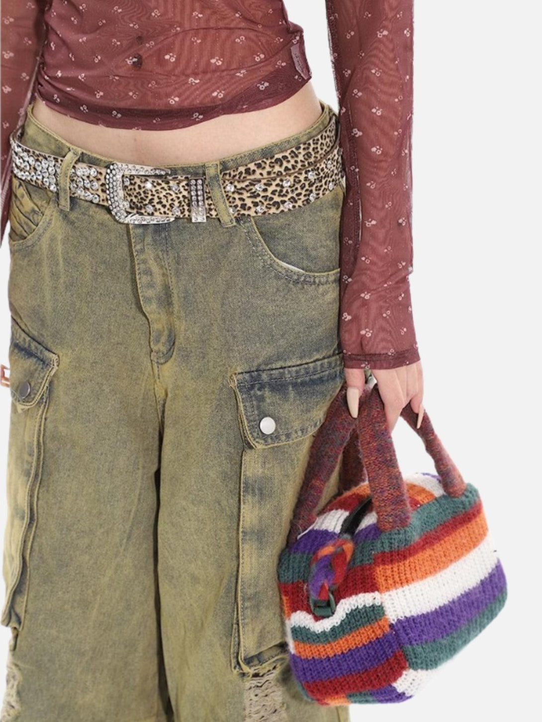 Model holding a colorful knitted bag with TALISHKO distressed jeans and leopard print belt.