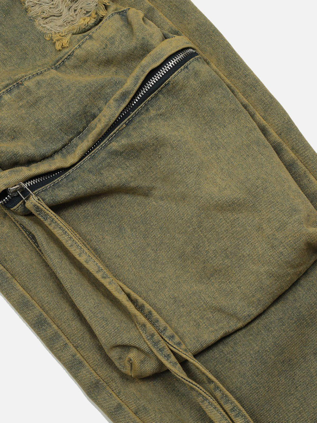 Intricate look at TALISHKO distressed jeans, highlighting rugged texture and zipper detail.