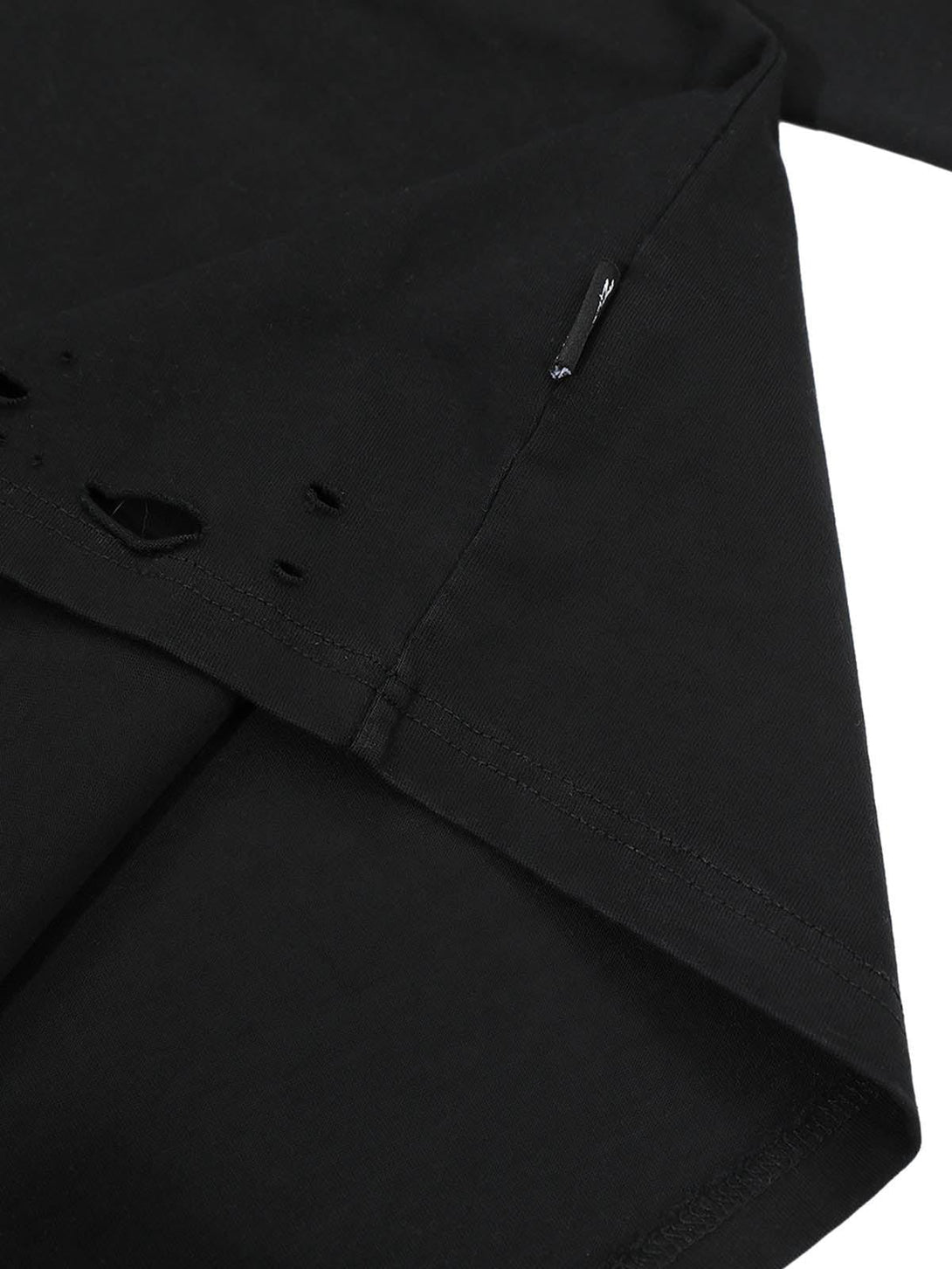 Intricate look at TALISHKO's distressed detailing on a black long sleeve t-shirt.