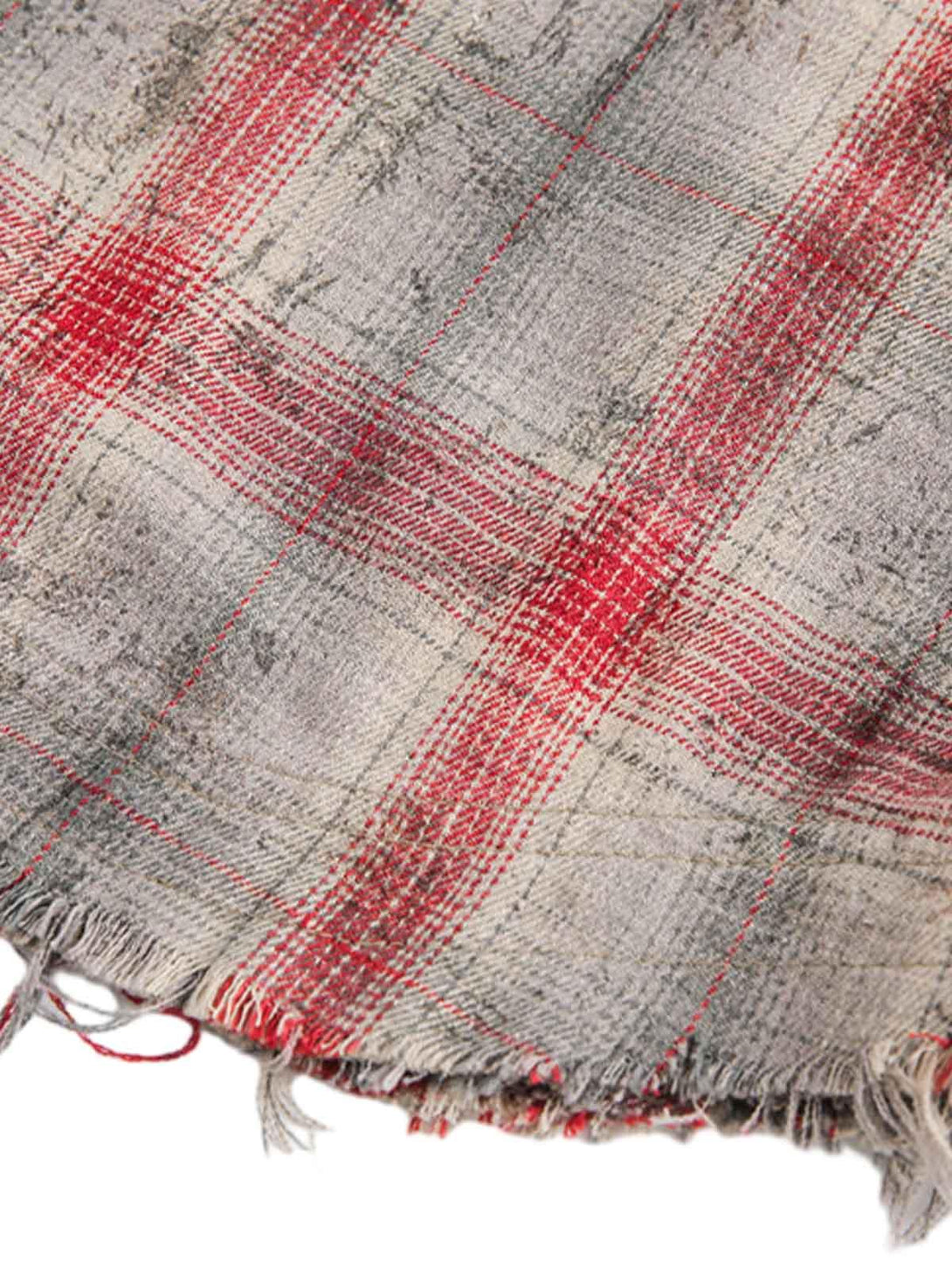 A tight crop highlighting the distressed plaid texture of a short-sleeve shirt by TALISHKO.