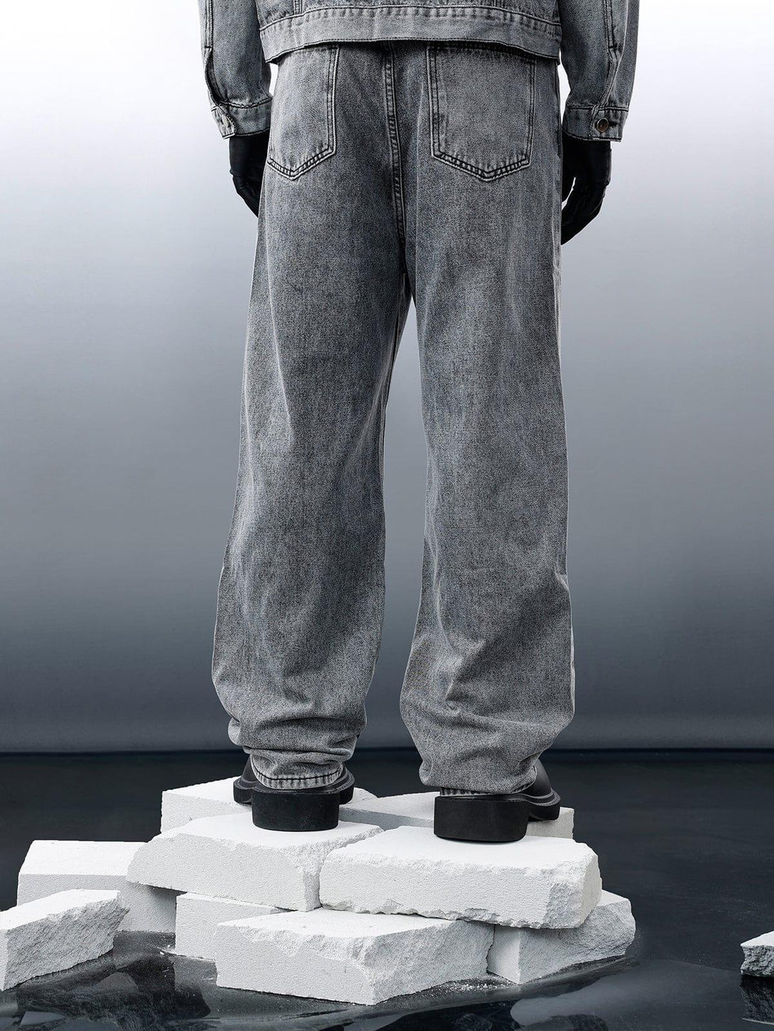Back view of gray distressed patchwork jeans by TALISHKO, highlighting modern streetwear style.