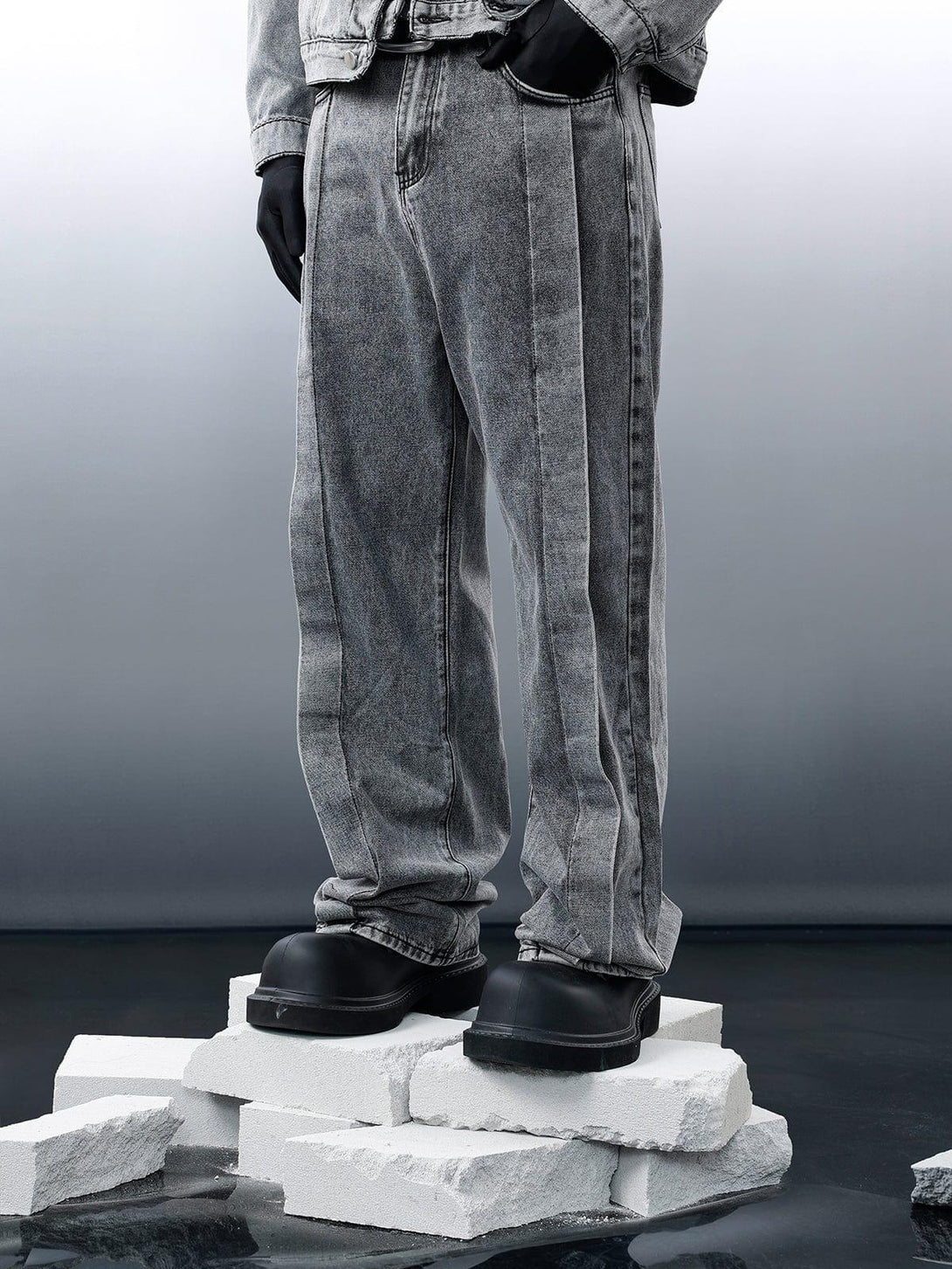 Model wearing gray TALISHKO distressed patchwork jeans, styled with black gloves and boots.