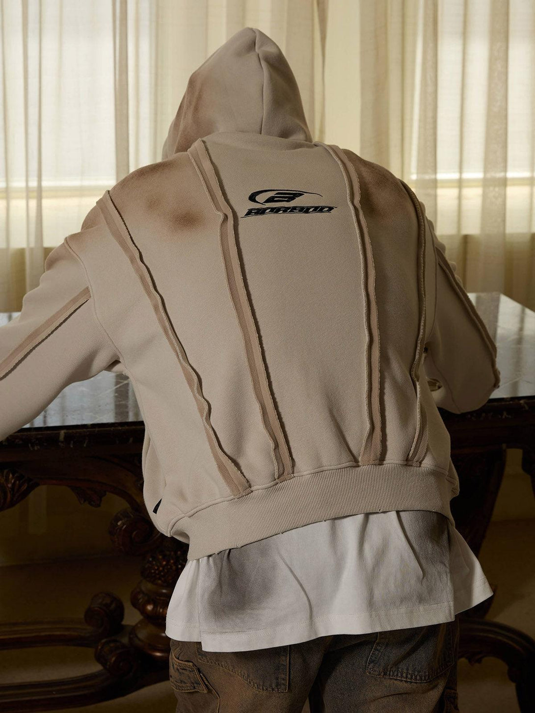 Rear view of TALISHKO distressed patchwork velvet jacket, showcasing unique stitching details.