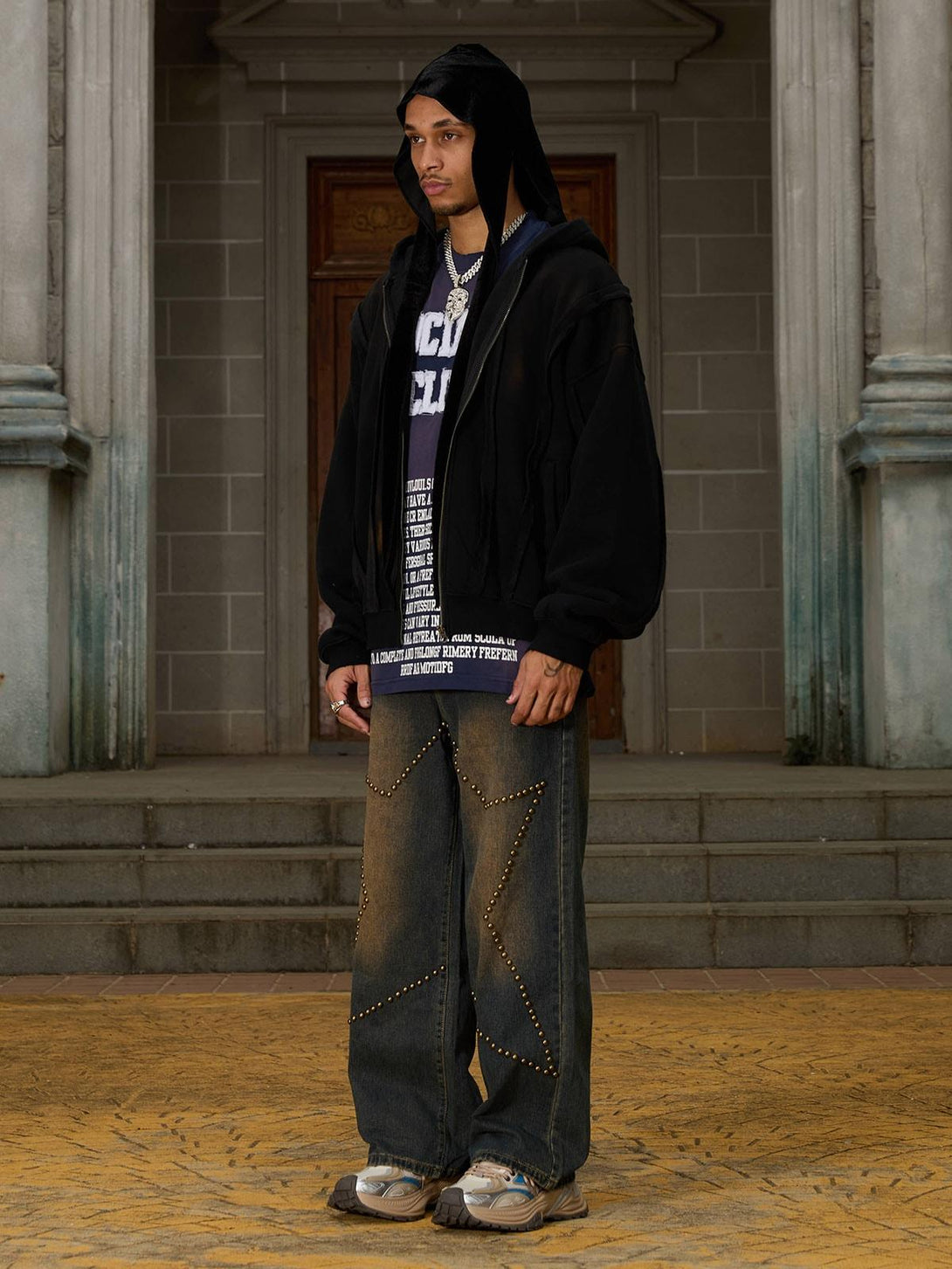 Model in TALISHKO velvet jacket with distressed patchwork, styled with studded jeans and sneakers.