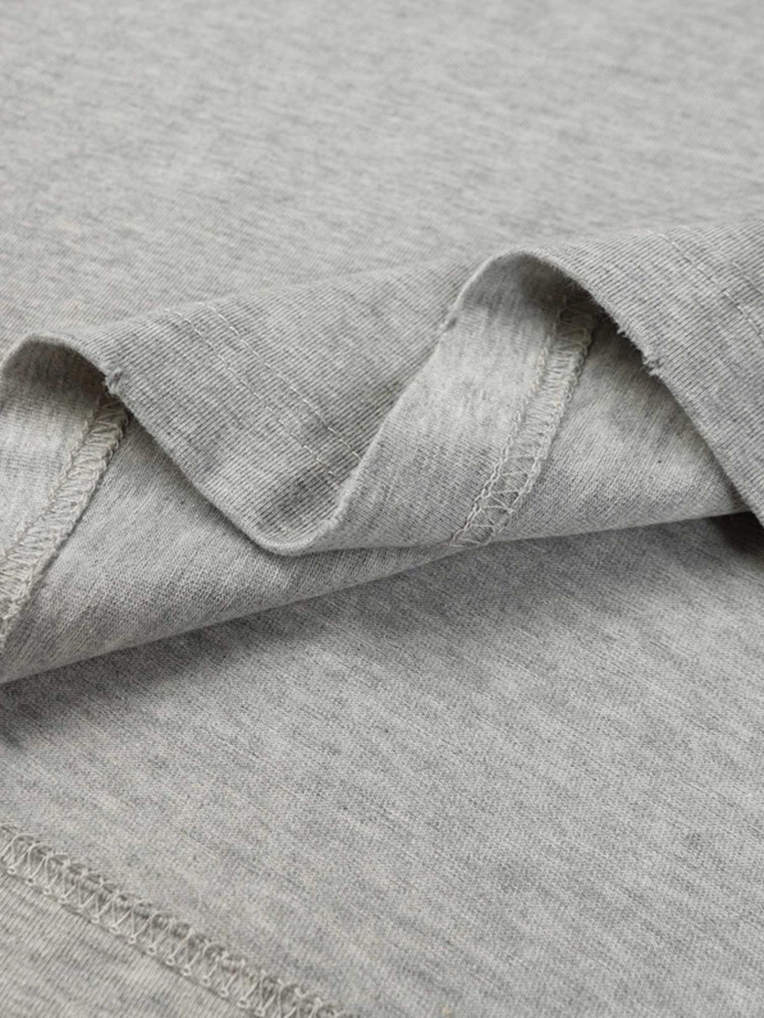 Detailed fabric and stitching of TALISHKO's gray T-shirt, showcasing its soft texture.