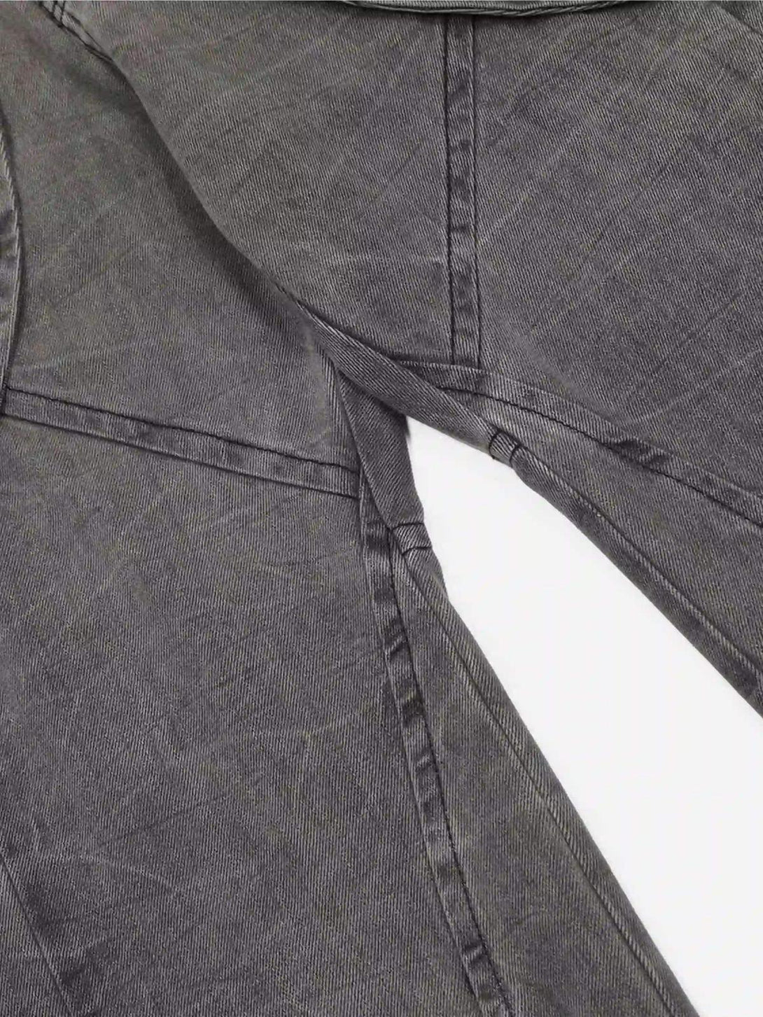 Detailed view of TALISHKO's distressed punk jeans, showcasing unique stitching and fabric texture.
