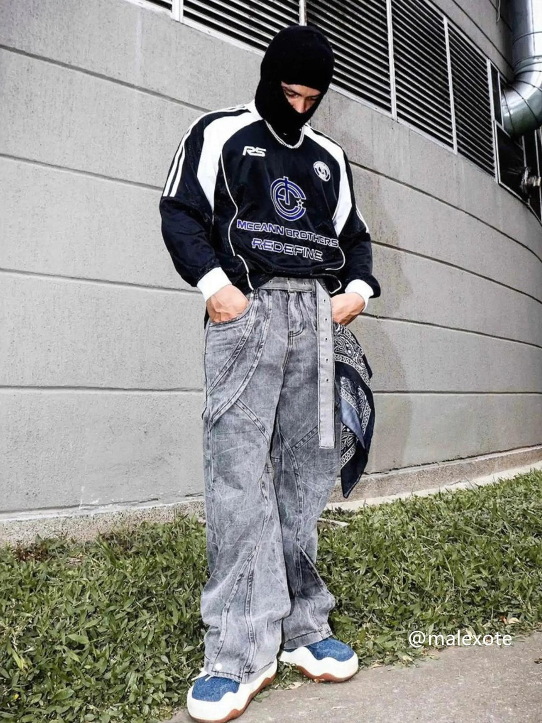 Model in TALISHKO distressed punk jeans with a metal belt, paired with a sporty top.